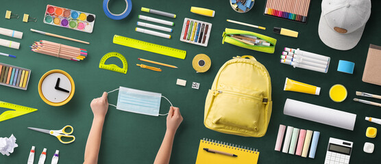 Flat lay top view of face mask and school supplies, back to school and coronavirus concept.
