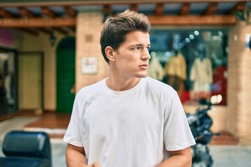 Fototapeta premium Young caucasian man with serious expression leaning walking at the city.