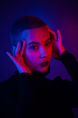 Portrait of a beautiful young woman with short hair in neon light