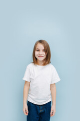 Portrait of a smiling 9 year old girl over blue background. Studio shot.