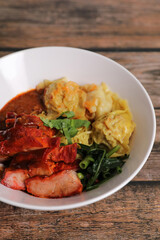 Shrimp dumpling with roasted pork with local thai tom yum spicy sauce on wood background