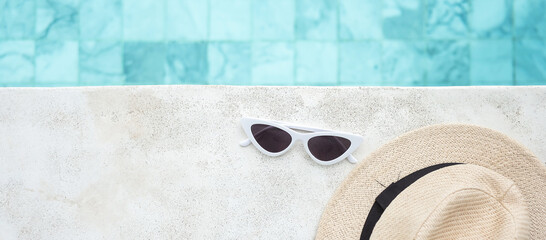 white sunglasses and hat near swimming pool in luxury hotel. Summer travel, vacation, holiday and...