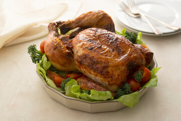 Whole chickenroasted, baked served with fresh vegetables. Thaksgiving food dinner.