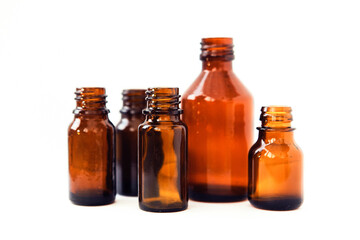 Dark brown phials on white background. Small empty bottles