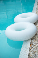 Couple white swim ring in luxury pool hotel, enjoy in tropical resort. Relaxing, summer travel, holiday, vacation and weekend concept