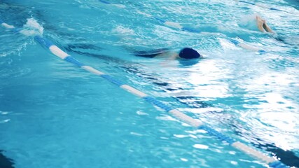 Three sportsmen perform butterfly swim