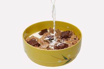 Pouring milk over cereals with chocolate