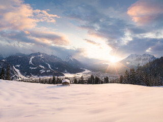Beautiful romantic winter covered landscape in the Alps during sunset