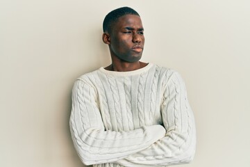 Obraz premium Young african american man wearing casual clothes looking to the side with arms crossed convinced and confident