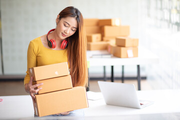 Portrait of Starting small businesses SME owners female entrepreneurs working, box and check online orders to prepare to pack the boxes, sell to customers, sme business ideas online.