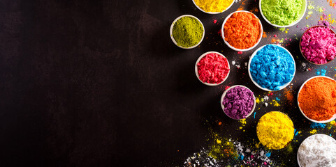 Happy holi festival decoration.Top view of colorful holi powder on dark background.