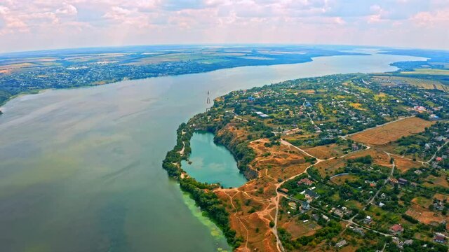 Aerial view over beautiful suburb with a wide river with  privat houses.  Top view over  a  people settlement near water.