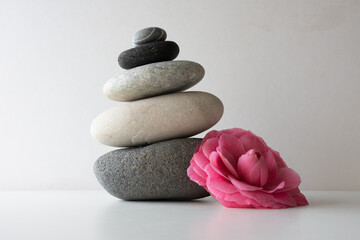 Fototapeta na wymiar pila de piedras zen con flor rosa