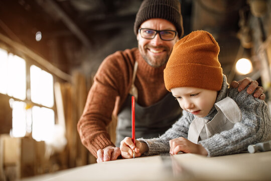 Happy Family Father And Son Working Together In Carpentry Workshop