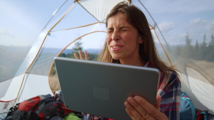 Excited girl talking about hike in mountains with friend by video call on tablet