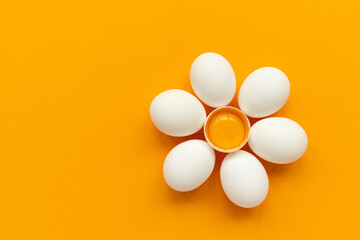 Flower make of white eggs and egg yolk into nest  on yellow and gray background. Top view. Flat lay. Easter celebration