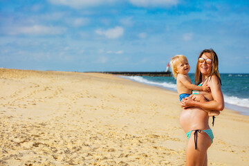 Mother and little toddler on the sea sand beach