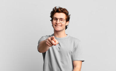 young handsome boy pointing at camera with a satisfied, confident, friendly smile, choosing you