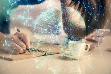 Double exposure of brain sketch hologram and woman holding and using a mobile device.