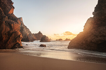 beautiful Atlantic ocean view horizon with sandy beach, rocks and waves at sunrise. Ursa beach,  Sintra, Portugal