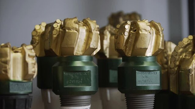 Brand new PDC Polycrystalline Diamond Compact drilling bit. Macro shot of drill bits on shelving in stock. Oil drilling equipment for drilling rig operation on oil platform in oil and gas industry.
