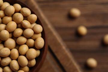 Natural soy beans on wooden table, closeup. Space for text