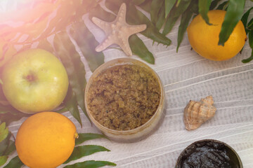 image of homemade cosmetics ingredients. aroma theme. Black mask, clay. organic cosmetics with extracts of herbs apples, lemons and oranges on white leaf green background