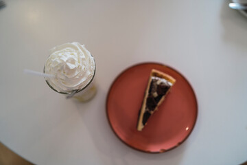 Batido de helado y porcion de tarta en mesa de cafeteria