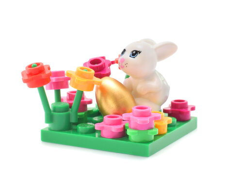 Lego figure happy white bunny is hunting easter eggs. Editorial illustrative image of Easter holiday.