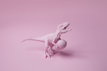 T rex dinosaur with easter egg on pink background. Funny Ester greating.