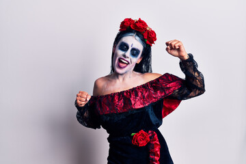 Young woman wearing mexican day of the dead makeup dancing happy and cheerful, smiling moving casual and confident listening to music