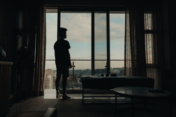 silhouette of a person standing at loft apartment window