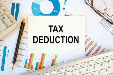 TAX DEDUCTION is written in a document on the office desk, keyboard and diagram