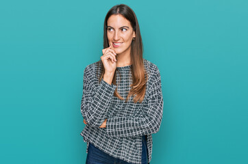 Young beautiful woman wearing casual clothes with hand on chin thinking about question, pensive expression. smiling with thoughtful face. doubt concept.