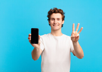 young boy smiling and looking friendly, showing number three or third with hand forward, counting...