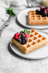 Belgian waffles with berries on a light plate.Breakfast