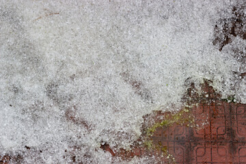 Close up accumulated hailstones on ground after a big hailing look like snow pile. Abnormal precipitation in Turkey. Extraordinary weather conditions as a result of climate change. Selective focus.

