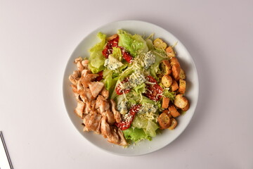 Salad with lettuce, sun-dried tomatoes, crutons and grilled chicken breast isolated overview