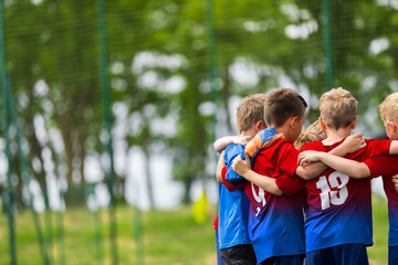 Happy Children Huddling in a Team on Sports Field. Group of School Boys Standing Together in a Circle and Motivating Themselves Before Football Match