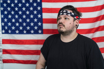 Chico con bandana de la bandera de estados unidos frente a la bandera americana