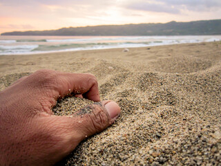 hand holding the beach sand