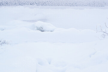 Fototapeta na wymiar Winter frozen snowy bank of river. Minimalism. Natural north landscape. Snowdrift
