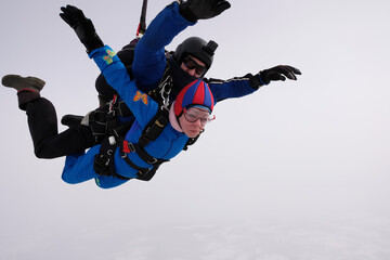 Skydiving. Tandem jump. Man and woman. Winter season.