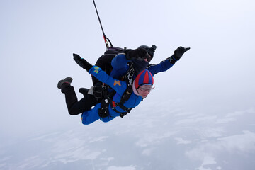 Skydiving. Tandem jump. Man and woman. Winter season.