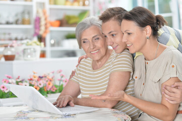 Happy family in front of laptop in kitchen
