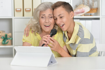 Grandson with grandmother with  tablet  singing karaoke