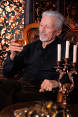portrait of  senior man  with glass at home