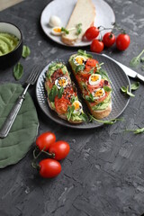 Delicious and healthy breakfast. Toast with fish, avocado and quail eggs on a gray plate. Proper nutrition.