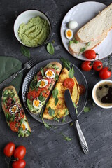 Delicious and healthy breakfast. Toast with fish, avocado and quail eggs on a plate with omelet. Proper nutrition.
