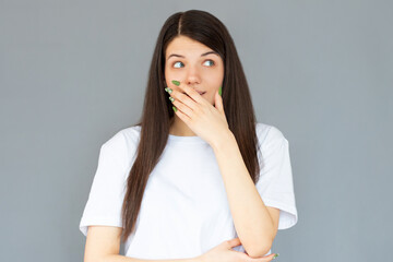 Happy woman closing her mouth with hand going to see surprise prepared by husband standing and smiling in anticipation for something wonderful. Young cheerful lady covering face with hand